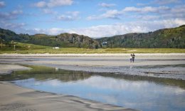 a couple of walking over the coastline at Calgary Bay, Mull